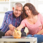 זוג יושב ומכניס כסף לקופת החסכון שלו